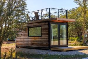 uma pequena casa com uma varanda em cima em New The Saguaro-Tiny Shipping Container Home em Fredericksburg