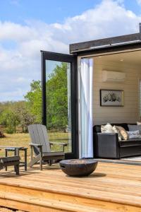 a patio with a couch and a chair on a deck at New The Yellow Beacon-Luxury Shipping Container in Fredericksburg
