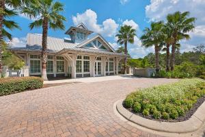 a house with palm trees and a brick driveway at Grande Pointe Sea Shell in Inlet Beach