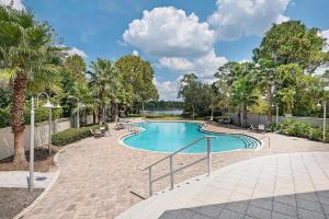 a swimming pool with tables and chairs and trees at Grande Pointe Sea Shell in Inlet Beach