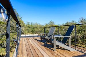 a deck with two chairs and a table on it at New! The Texas Longhorn-Luxury Container Home in Fredericksburg