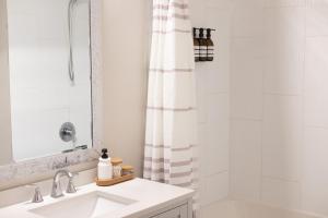 a white bathroom with a sink and a shower at New Spacious Studio Suite with Mountain Views in Kamloops