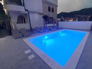 ein Pool mit blauen Lichtern an einem Gebäude in der Unterkunft Apartments Amfora in Barbat na Rabu