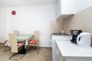 eine Küche mit einer Theke, einem Tisch und Stühlen in der Unterkunft Apartments Jadranka in Grebaštica