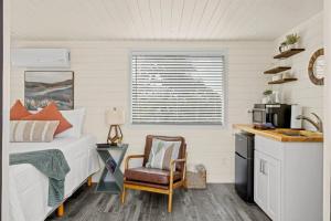 a bedroom with a bed and a chair and a kitchen at New The Sunset Luxury Container Home in Fredericksburg