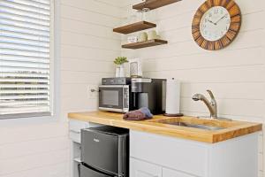 a kitchen with a counter with a microwave and a sink at New The Sunset Luxury Container Home in Fredericksburg