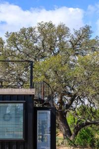 a black building with a tree in the background at New The Sunset Luxury Container Home in Fredericksburg