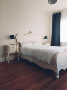 a bedroom with a white bed and two night tables at Grá na Farraige in Enniscrone