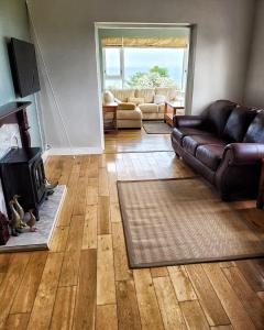 a living room with a leather couch and a fireplace at Lighthouse Farm in Greencastle