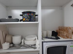Küche mit Geschirr und Mikrowelle in der Unterkunft Всё-всё новое "от и до" in Oral