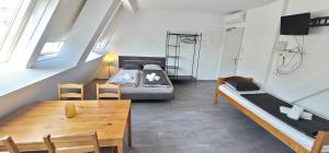 Cette chambre comprend deux lits, une table et des chaises. dans l'établissement ToTa Studio, à Vienne