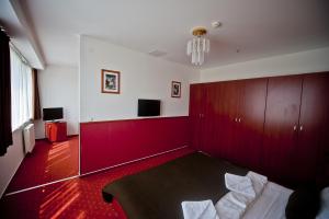 Habitación con pared roja, cama y mesa. en Canada Hotel Budapest, en Budapest