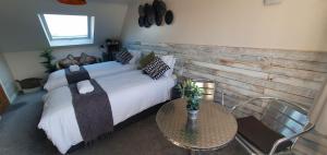 Schlafzimmer mit einem Bett und einem Tisch mit einem sidx sidx sidx in der Unterkunft Arundel Comfort En Suite Twin Friends & Family in Arundel