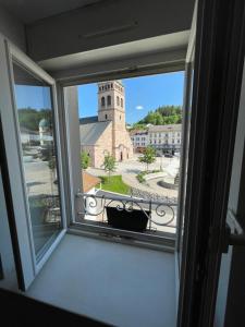 a window with a view of a church at Charmant F3 à Gérardmer Centre in Gérardmer +2 photos