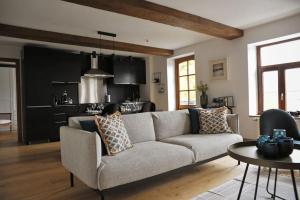 een woonkamer met een bank en een keuken bij Gîte de charme bord de Meuse in Namen