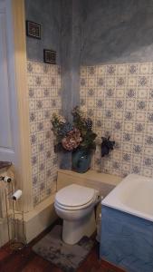 a bathroom with a toilet and a vase of flowers at La chambre bleue in Bussang