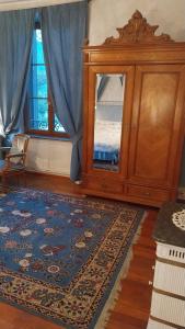 a living room with a cabinet and a rug at La chambre bleue in Bussang