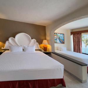 a hotel room with two beds and a window at The Palms Resort of Mazatlan in Mazatlán