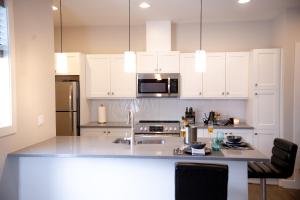 a kitchen with white cabinets and a counter top at New Spacious Studio Suite with Mountain Views in Kamloops
