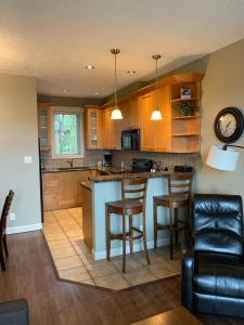 a kitchen with wooden cabinets and a counter top at Race Rocks Townhouse - Sooke in Sooke