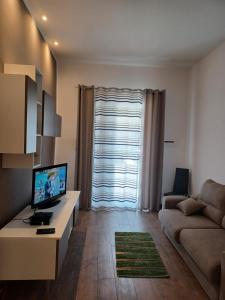 un soggiorno con un divano e un tavolo con una televisione di GIORGISA a Palermo