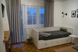 Un dormitorio con una cama frente a una ventana. en SUNSET STATION APARTMENTS ZAGREB, en Zagreb