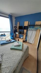 - une chambre avec un lit et un mur bleu dans l'établissement Los Abrigos Ocean relax, wifi, playas, à Los Abrigos