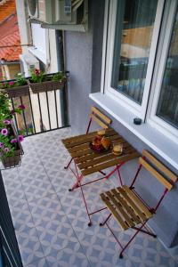 un porche con banco, mesa y ventana en SUNSET STATION APARTMENTS ZAGREB, en Zagreb