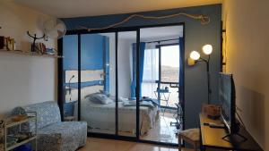 - un salon avec une chambre dotée d'un lit et d'un miroir dans l'établissement Los Abrigos Ocean relax, wifi, playas, à Los Abrigos