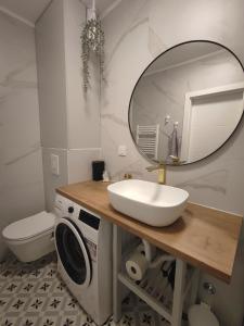 Un baño con lavabo y lavadora. en SUNSET STATION APARTMENTS ZAGREB, en Zagreb
