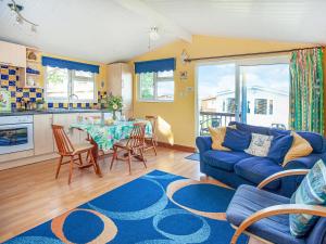 a living room with a blue couch and a table at Skylarks in St Merryn