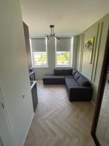 un soggiorno con divano e 2 finestre di Airport Apartment 14 Self Check-In Free parking a Vilnius