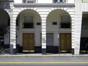 a building with three arched doors on a street at Libertador recoleta in Buenos Aires