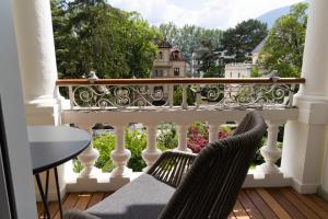 balcón con 2 sillas y vistas a un edificio en Luxury Apartment Villa Ortler, en Merano