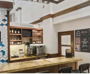 a restaurant with a counter and a coffee shop at Hyatt Place Boston/Medford in Medford