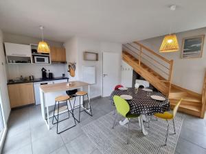 a kitchen and dining room with a table and chairs at La Cabane Océan 10 min a pied de Mimizan plage Forêt in Mimizan