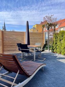une terrasse avec une table, des chaises et une planche de surf dans l'établissement Saphir Quartier, à Quedlinbourg
