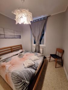 ラ・スペツィアにあるNest Restのベッドルーム1室(ベッド1台、窓、シャンデリア付)