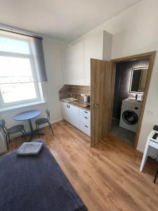 a room with a bed and a table and a kitchen at 29 Airport Apartment in Vilnius