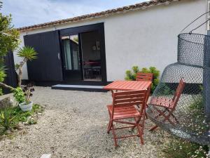 two chairs and a table in front of a house at Ma Chambre d'Amis in Saint-Clément-des-Baleines
