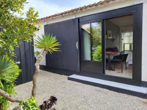 a house with a sliding glass door with a table at Ma Chambre d'Amis in Saint-Clément-des-Baleines