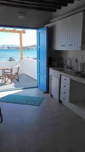 cocina con mesa y vistas al océano en Apleton Beach House Kimolos at Zacharias Beach en Kimolos