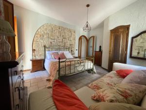 a bedroom with a bed and a couch at DOMUS PARVA - Villa con bio-piscina, spa privata e appartamenti panoramici in Bacoli +33 photos