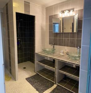 a bathroom with two sinks and a mirror at Cottage OVERLORD - 6 personnes - Plages du débarquement in Formigny