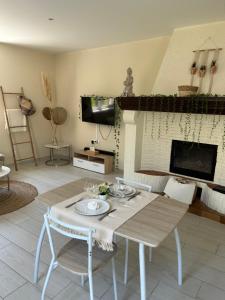 ein Wohnzimmer mit einem Tisch, Stühlen und einem Kamin in der Unterkunft Escapade amoureuse - Jaccuzi et Sauna PRIVÉ in Fontenoy