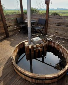 un pequeño estanque en una terraza de madera con mesa y sillas en Domos Mi Espacio Rustiko en San Carlos