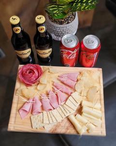 una tabla de cortar con queso y dos botellas de cerveza en Domos Mi Espacio Rustiko en San Carlos