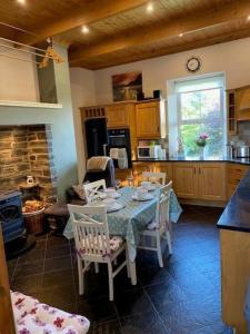 uma cozinha com uma mesa com cadeiras e um fogão em Beechwood View em Kilrush