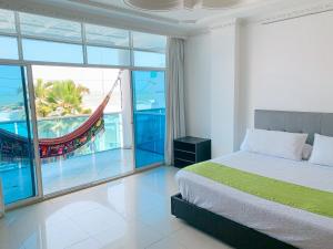 a bedroom with a bed and a balcony with a hammock at Hotel Abi Inn By GEH Suites in Cartagena de Indias