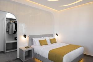 a bedroom with a large white bed with yellow pillows at Santa Mar ECO Suites in Karterados